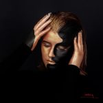 Jeune femme maquillée noir et or.