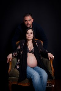 Séance photo grossesse. Un couple pose en studio.